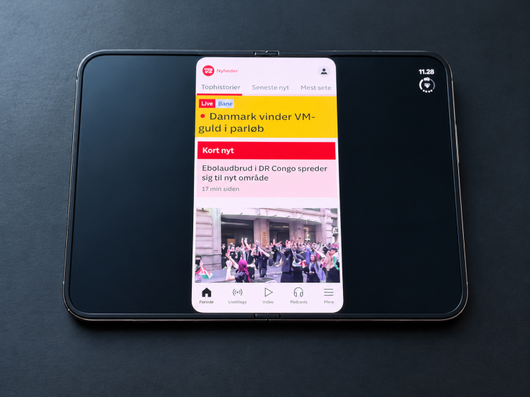 TV 2 Nyheder-appen vises i et smalt felt med store sorte områder på iPhone Duos udfoldede skærm.